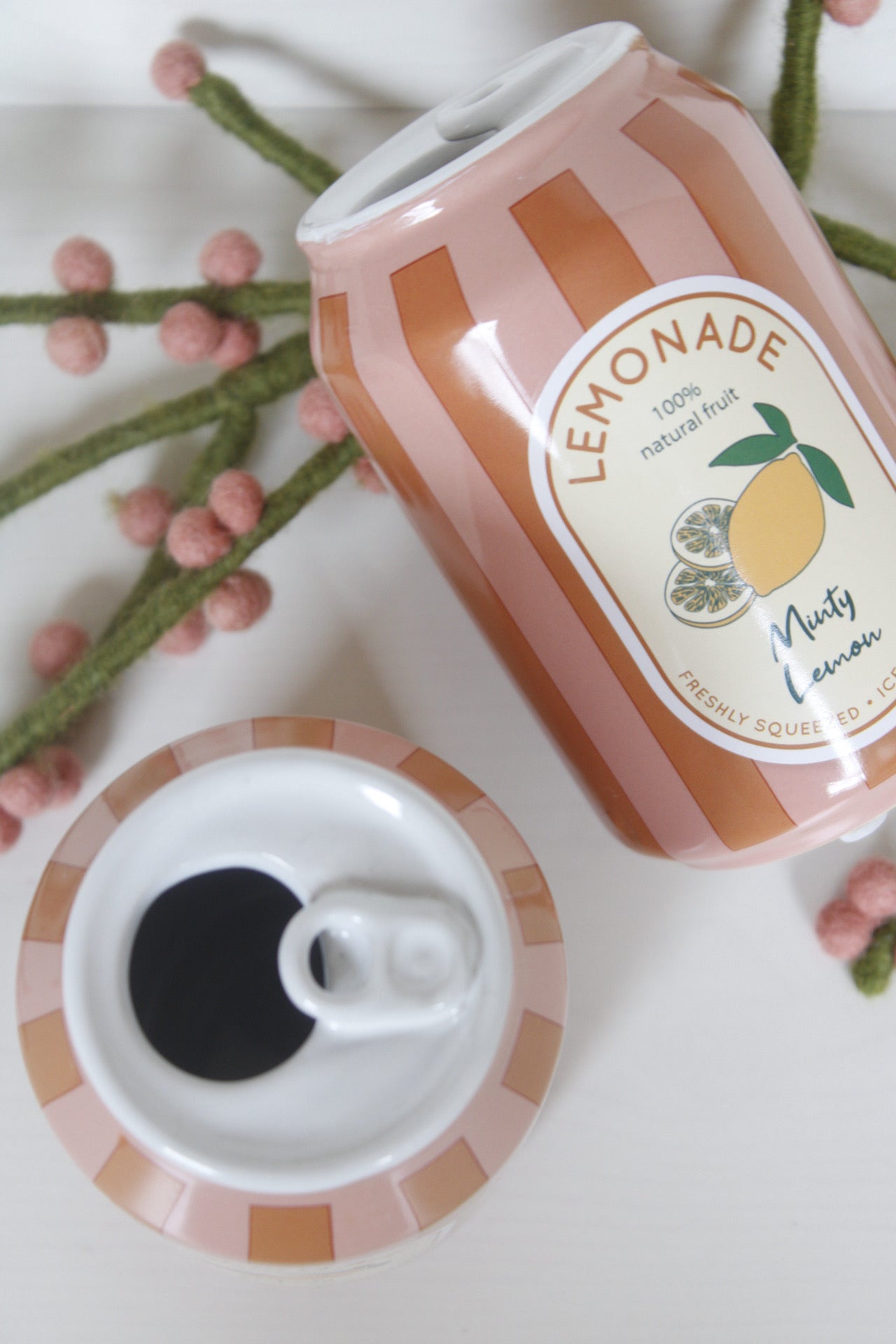 kleine Vasen in Limonadendosen-Form mit Zweig, eine Dose liegend