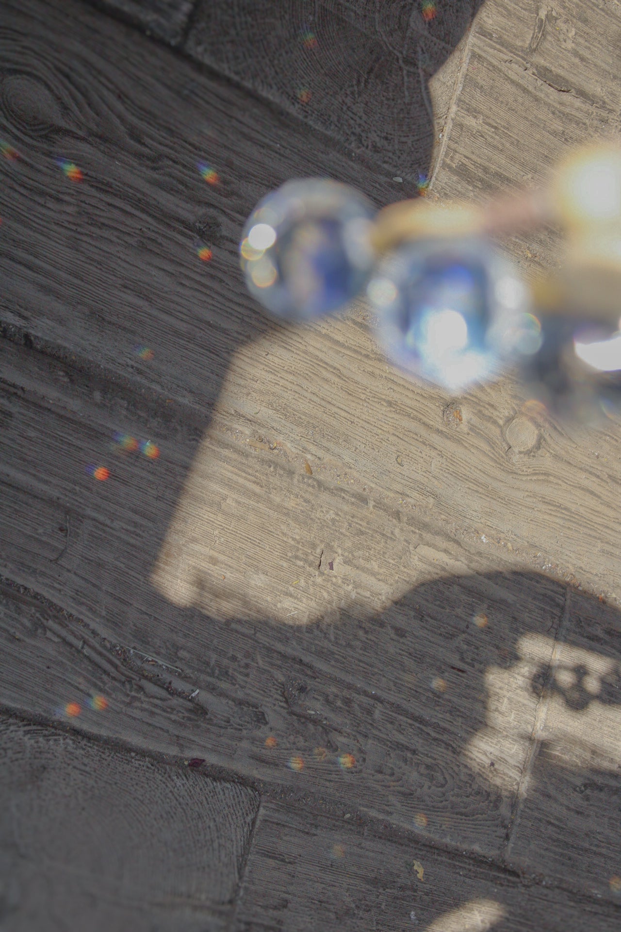 Suncatcher die in die Sonne gehalten werden und kleine Regenbögen auf den Boden werfen