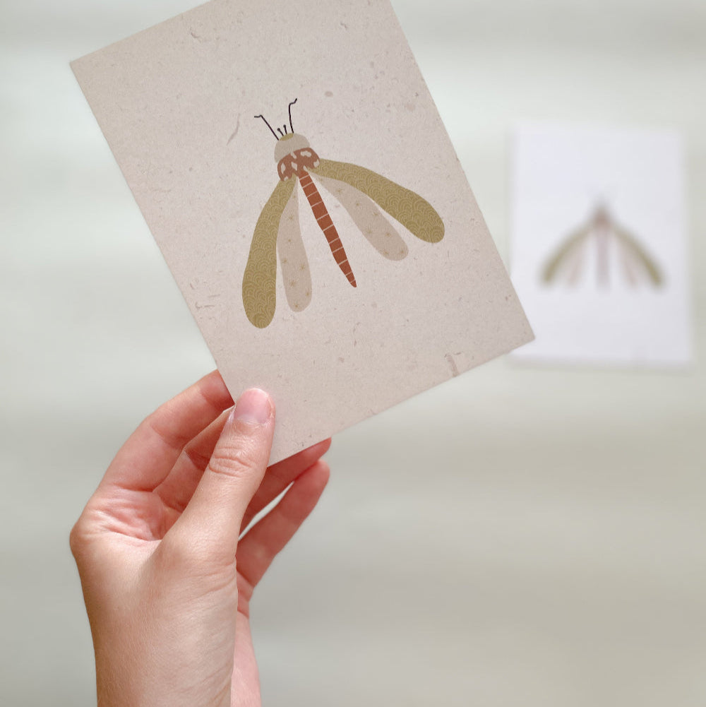 Postkarte ‚Libelle‘ – Elegantes minimalistisches Design mit Blumenmuster, Vorderseite im Detail, von Hand gehalten