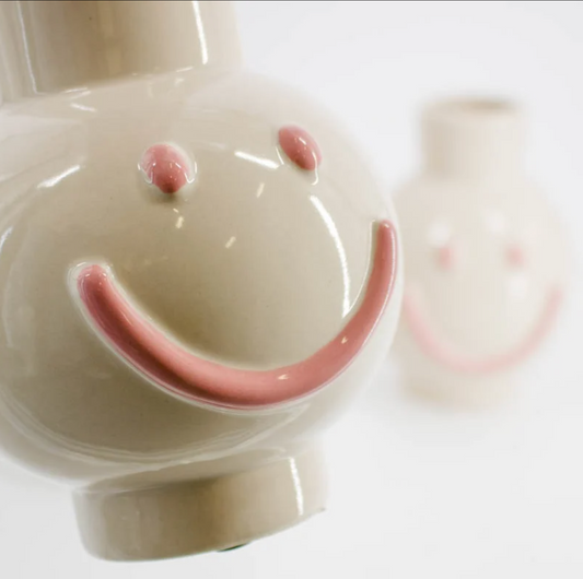 Keramikvase von Home Bound aus den Niederlanden in einer Nahaufnahme mit rosanem Smileygesicht.
