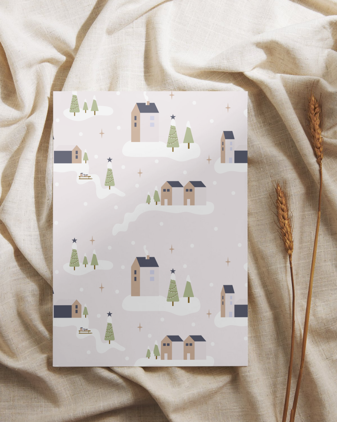 Weihnachtliche Postkarte in hellen Tönen mit Weihnachtsdorf Motiv. Fotografiert auf einem braunen Leinentuch