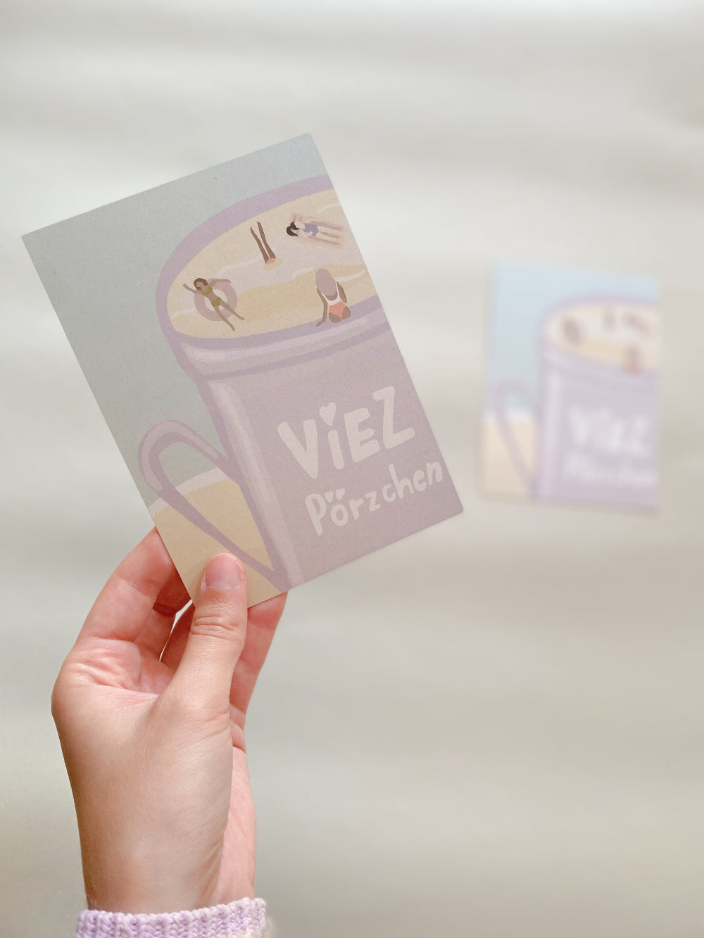 Postkarte ‚Viezpörzchen‘ – Humorvolle Trier-Souvenirkarte mit Viezkrug als Swimming Pool, Karte wird von Hand gehalten