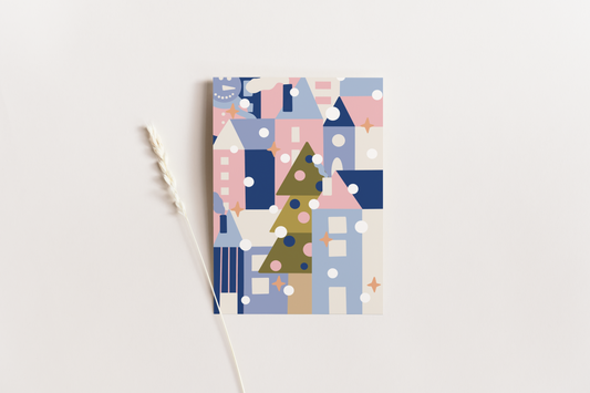 Bunte, weihnachtliche Postkarte im DIN A6 Format. Fotografiert auf einem beigen Hintergrund.