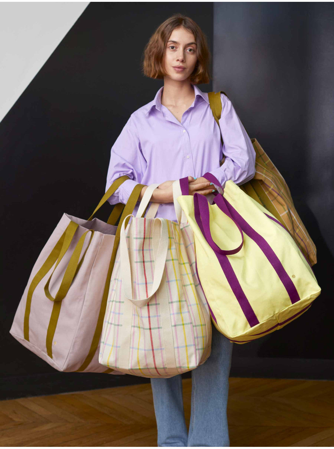 Maxi Poppins Tasche von La Cerise sur le Gateau – große Einkaufstasche aus Portugal, ideal für Büro, Strand und Reisen, Model hält unterschiedliche Farbvarianten der Tasche in den Haenden